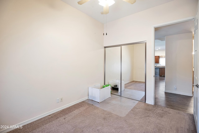 unfurnished bedroom with carpet, a closet, and ceiling fan