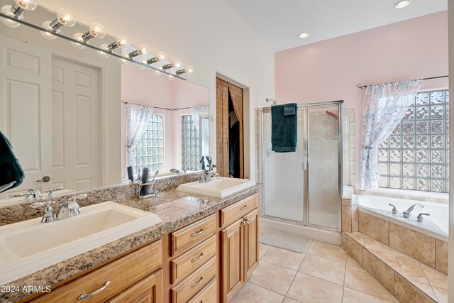 bathroom featuring plus walk in shower, vanity, and tile patterned floors