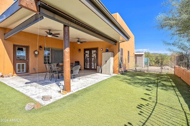 back of property featuring a lawn, ceiling fan, french doors, and a patio