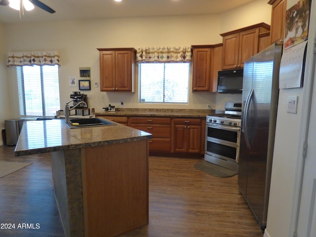 kitchen featuring dark wood-type flooring, sink, a kitchen island, and stainless steel appliances