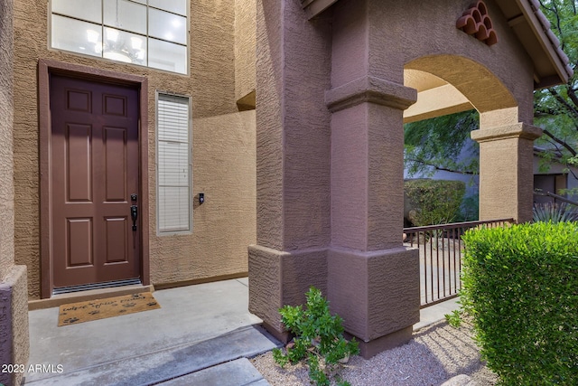 view of exterior entry with a balcony