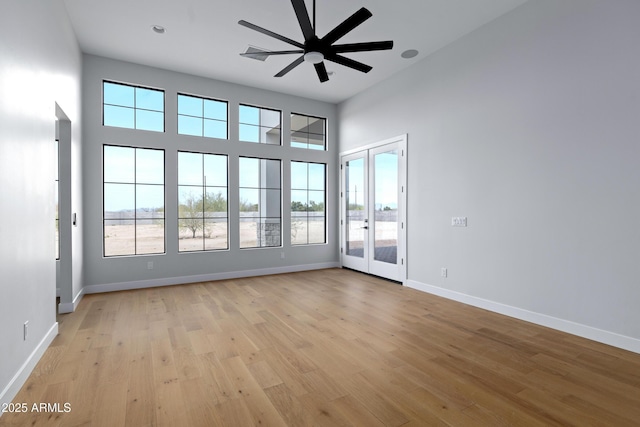 10760 W Golddust Dr, Queen Creek, AZ 85144 - spare room with light wood-type flooring, french doors, baseboards, a towering ceiling, and a ceiling fan