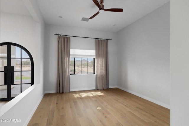 10760 W Golddust Dr, Queen Creek, AZ 85144 - unfurnished room with baseboards, light wood-style flooring, and a healthy amount of sunlight