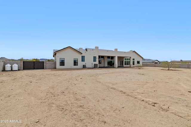 10760 W Golddust Dr, Queen Creek, AZ 85144 - rear view of property with stucco siding, a gate, and fence