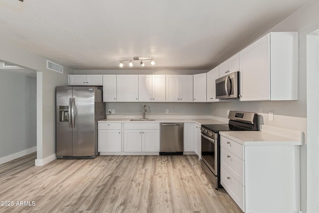 13202 N 40th Pl, Phoenix, AZ 85032 - kitchen featuring stainless steel appliances, light wood-style floors, light countertops, and white cabinetry