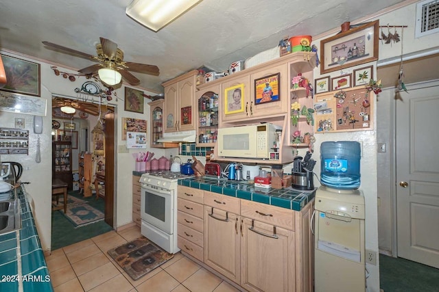 kitchen with ceiling fan, light tile patterned flooring, white appliances, tile counters, and light brown cabinetry