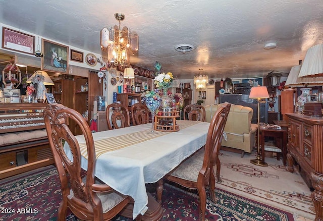 carpeted dining room featuring a textured ceiling and an inviting chandelier