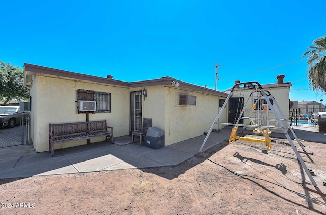 back of property featuring cooling unit, a patio area, and a wall mounted air conditioner