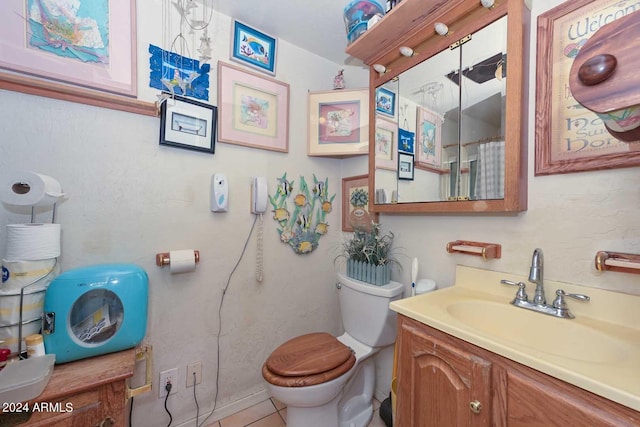 bathroom featuring tile patterned flooring, curtained shower, vanity, and toilet