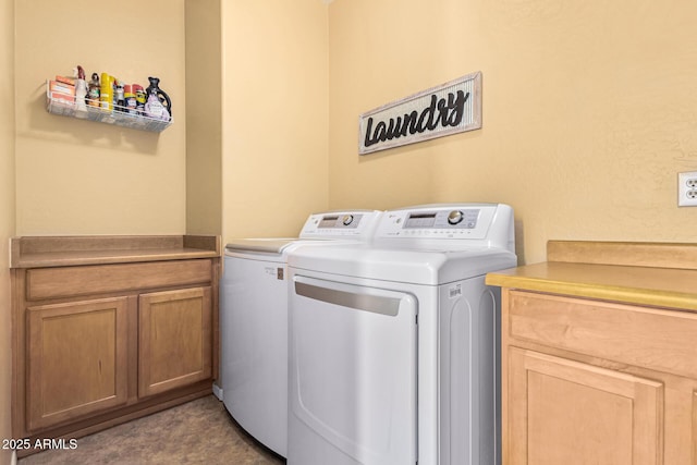 laundry room featuring cabinets and washer and clothes dryer