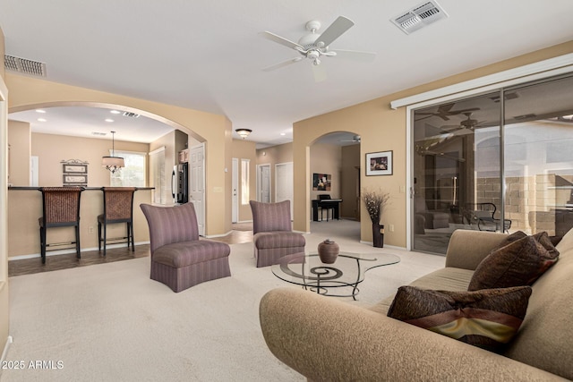 carpeted living room with ceiling fan