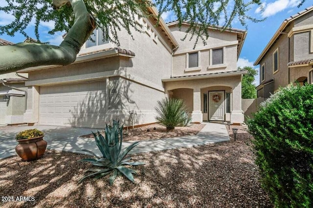 view of front of house with a garage, stucco siding, and concrete driveway