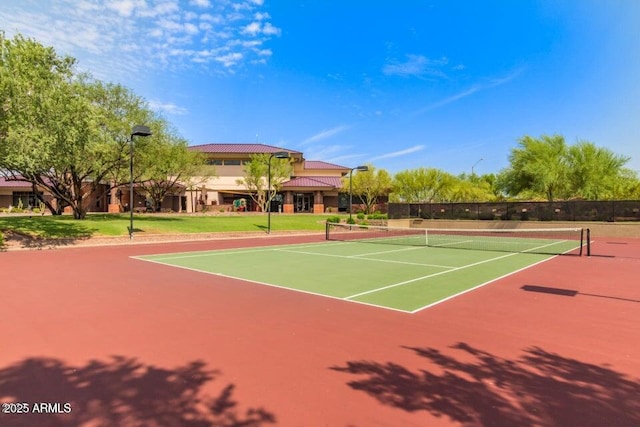 view of tennis court with community basketball court and fence