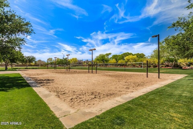 view of property's community with volleyball court and a yard