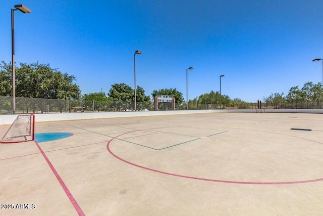 view of basketball court featuring community basketball court, fence, and a sport area