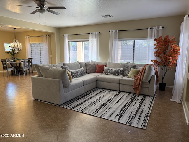 living room with a chandelier, ceiling fan, and baseboards