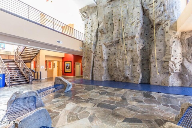 common area featuring a towering ceiling and stairs