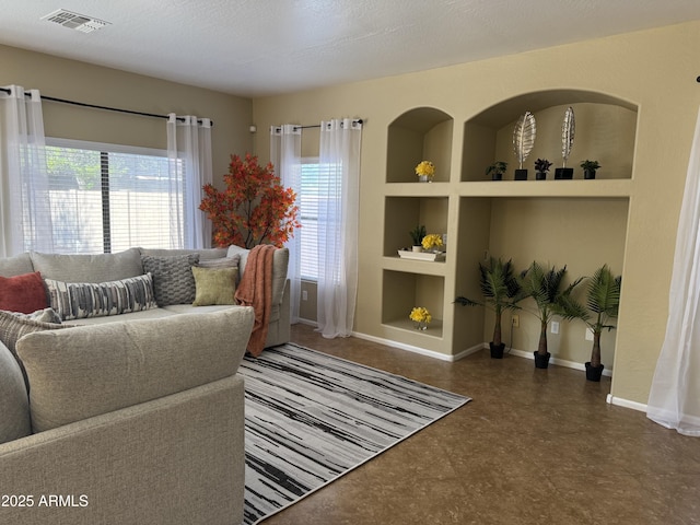 living area with built in features, plenty of natural light, tile patterned floors, and baseboards