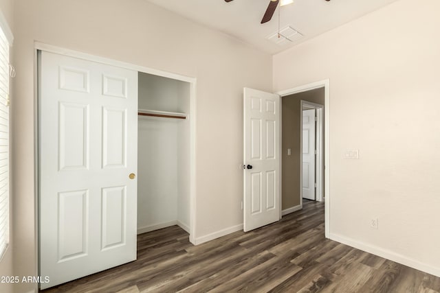 unfurnished bedroom with dark wood finished floors, a closet, baseboards, and ceiling fan