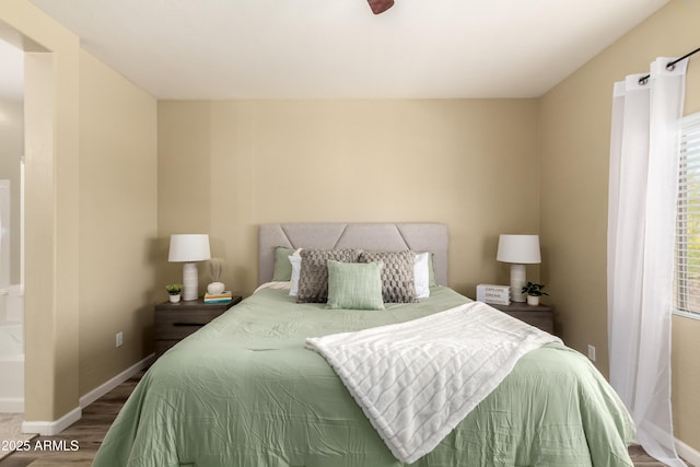 bedroom with wood finished floors and baseboards