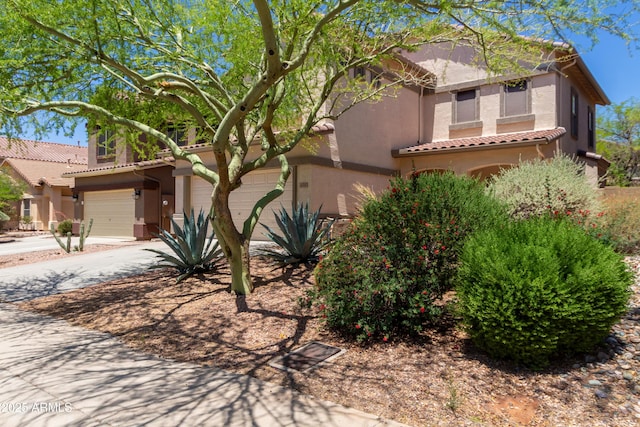mediterranean / spanish-style home with a tile roof, stucco siding, and driveway
