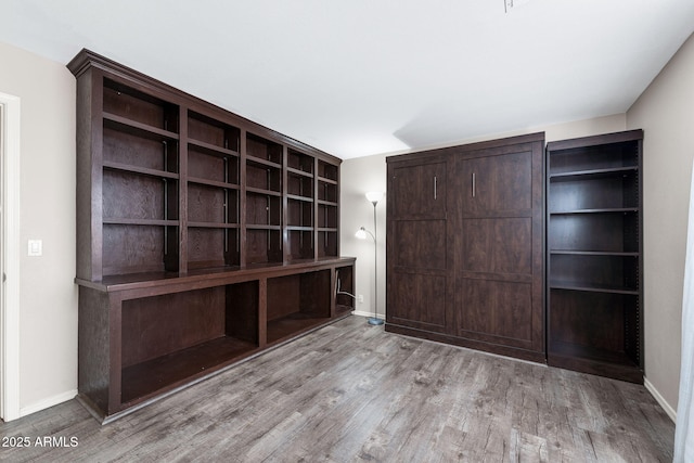 unfurnished bedroom featuring wood finished floors and baseboards