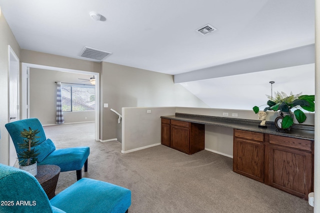 office featuring light carpet, baseboards, visible vents, and built in desk