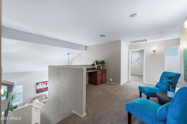 interior space featuring carpet floors, baseboards, visible vents, and an upstairs landing