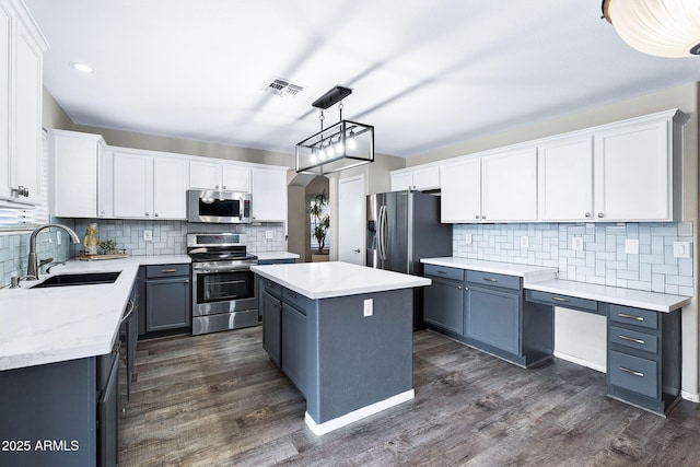 kitchen featuring visible vents, appliances with stainless steel finishes, dark wood-type flooring, and a sink