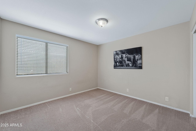 spare room with carpet and baseboards