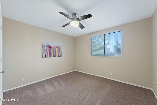 empty room with ceiling fan, carpet, and baseboards