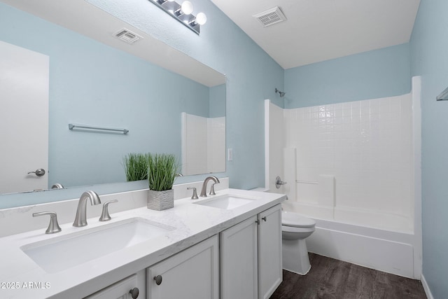 bathroom featuring toilet, visible vents, and a sink