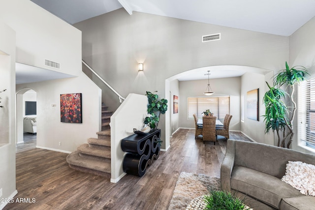 interior space featuring stairs, visible vents, arched walkways, and wood finished floors