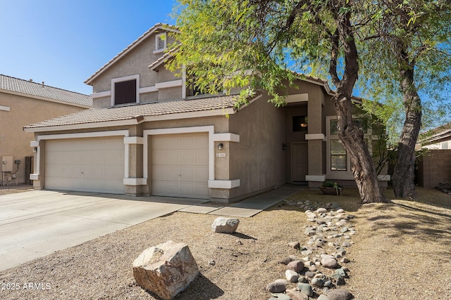 view of front facade featuring concrete driveway, a tiled roof, and stucco siding