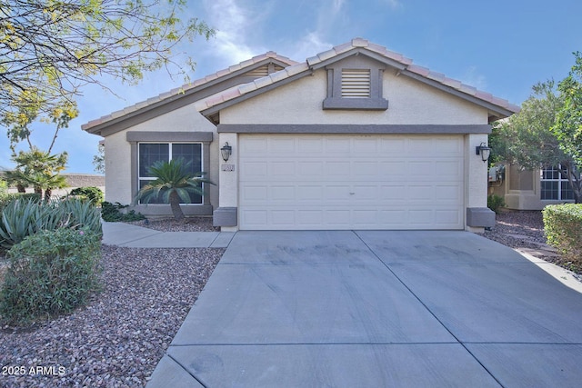 ranch-style house with concrete driveway, an attached garage, a tile roof, and stucco siding