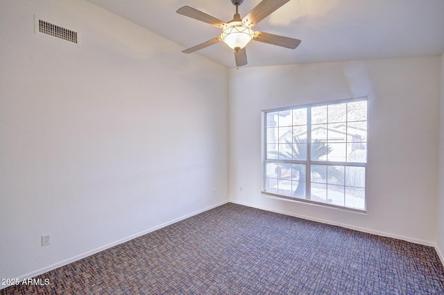 unfurnished room featuring ceiling fan, dark carpet, and vaulted ceiling