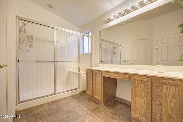 bathroom with vanity, a shower with door, and vaulted ceiling