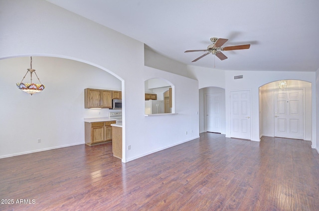 unfurnished living room with vaulted ceiling, ceiling fan, dark wood-type flooring, and visible vents