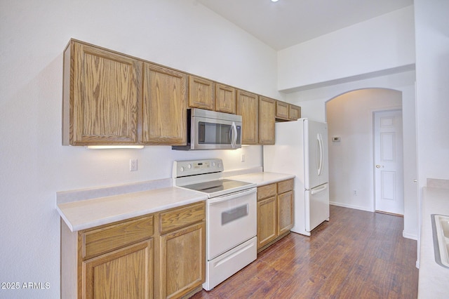 kitchen with dark hardwood / wood-style floors and white appliances