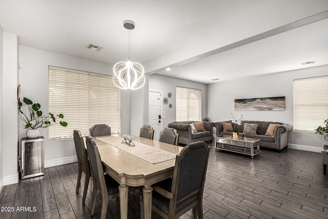 dining space featuring dark hardwood / wood-style floors and a chandelier