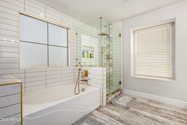 bathroom with hardwood / wood-style flooring and independent shower and bath