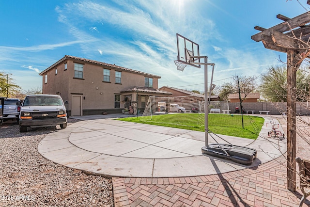 view of sport court with a yard