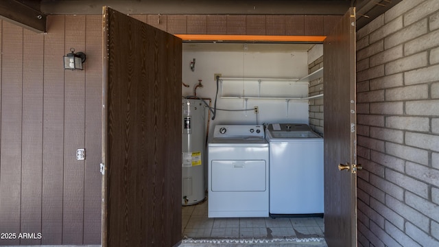 clothes washing area featuring water heater and washing machine and clothes dryer