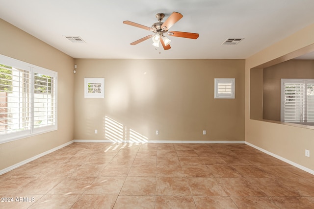 tiled spare room with ceiling fan