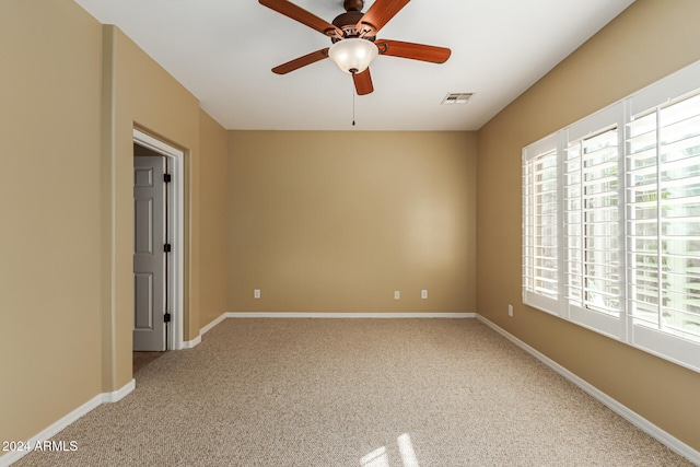 carpeted spare room with ceiling fan