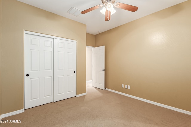 unfurnished bedroom with light carpet, ceiling fan, and a closet