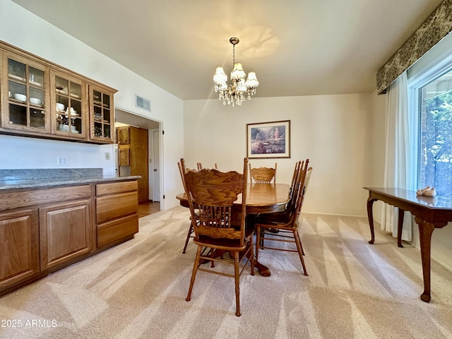 carpeted dining area featuring a notable chandelier