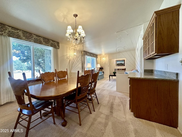 carpeted dining area featuring a notable chandelier