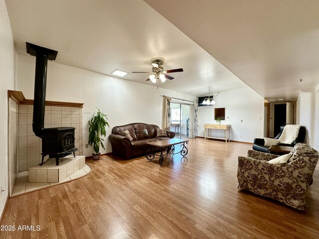 living room featuring hardwood / wood-style floors, ceiling fan, and a wood stove