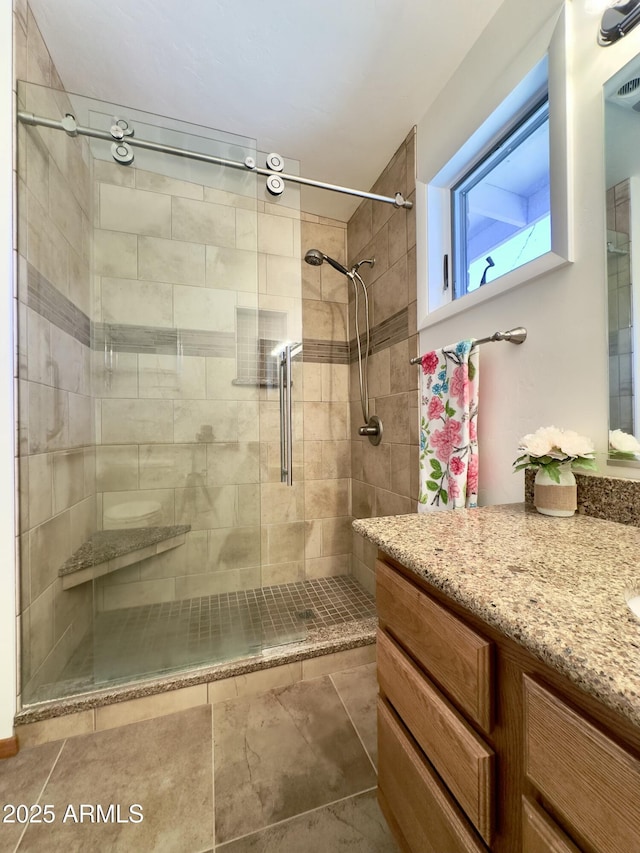 bathroom featuring vanity and a shower with door